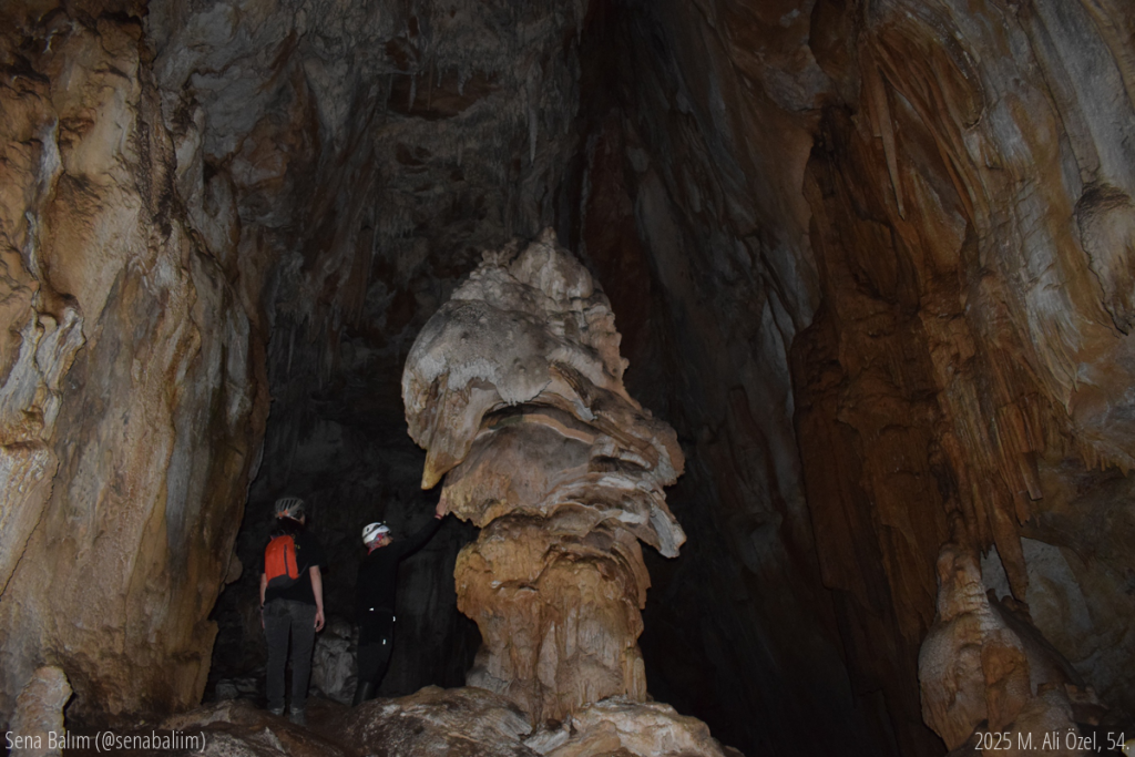 büyük mantara benzeyen oluşumun yanında küçük duran mağaracılar